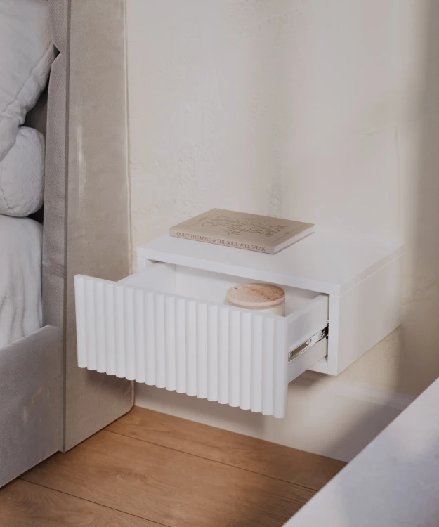 Nowoczesny stolik nocny wiszący BIAŁY z praktyczną szufladą oraz ryflowanym frontem. Solidna konstrukcja, trwałe materiały i elegancki wygląd sprawiają, że doskonale sprawdzi się w każdej sypialni.